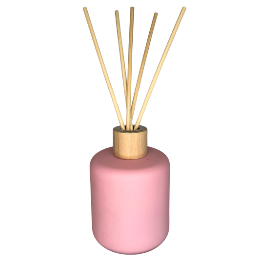baby pink coloured reed diffuser with 5 reeds placed inside